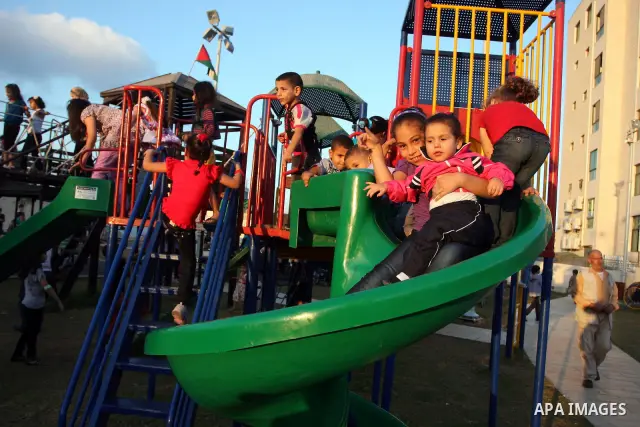 Palestinian children enjoy a ride at an amusement park on the second day of the Eid al-Fitr holiday, which marks the end of the holy fasting month of Ramadan, in the West Bank city of Ramallah, 31 August 2011. Photo by I...