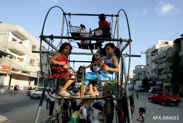 Palestinian children enjoy a ride at an amusement park at the second day of the Eid al-Fitr holiday, which marks the end of the holy fasting month of Ramadan in Rafah in the southern Gaza Strip on August 31 2011. Photo b...