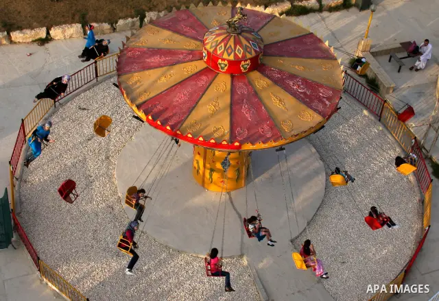 Palestinian children enjoy a ride at an amusement park on the second day of the Eid al-Fitr holiday, which marks the end of the holy fasting month of Ramadan, in the West Bank city of Nablus, 31 August 2011. Photo by Wag...