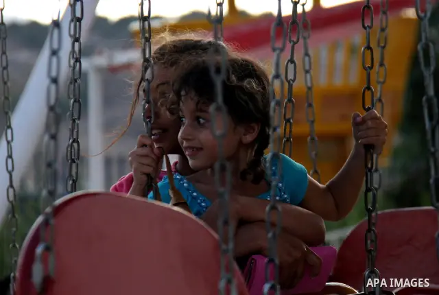 Palestinian children enjoy a ride at an amusement park on the second day of the Eid al-Fitr holiday, which marks the end of the holy fasting month of Ramadan, in the West Bank city of Nablus, 31 August 2011. Photo by Wag...