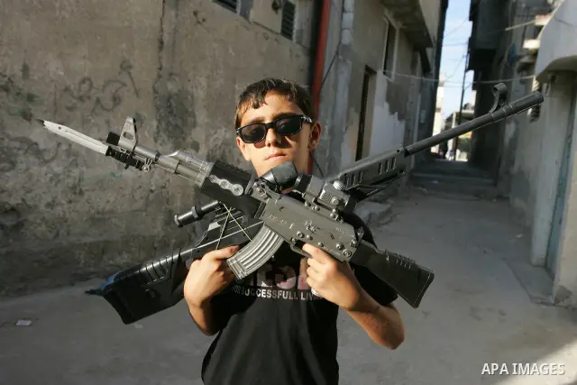 Palestinian boys play with toy guns on the third day of the Eid al-Fitr holiday in Rafah Refugee Camp in the southern Gaza Strip on 01 September 2011. Eid marks the end of the holy month of Ramadan. Photo by Abed Rahim K...