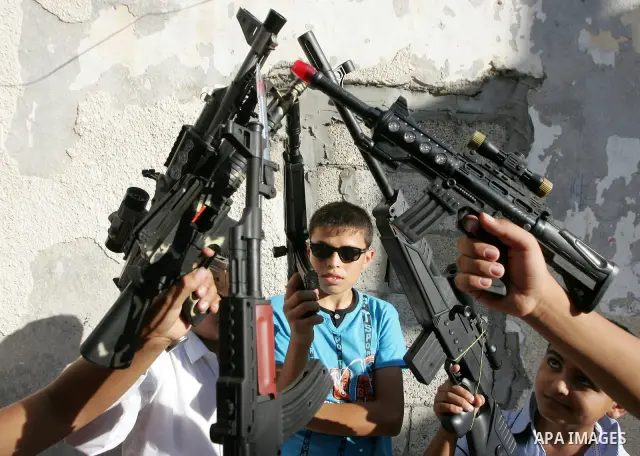 Palestinian boys play with toy guns on the third day of the Eid al-Fitr holiday in Rafah Refugee Camp in the southern Gaza Strip on 01 September 2011. Eid marks the end of the holy month of Ramadan. Photo by Abed Rahim K...