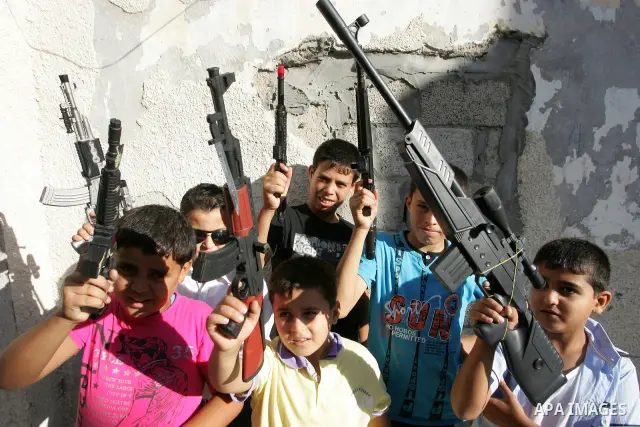 Palestinian boys play with toy guns on the third day of the Eid al-Fitr holiday in Rafah Refugee Camp in the southern Gaza Strip on 01 September 2011. Eid marks the end of the holy month of Ramadan. Photo by Abed Rahim K...