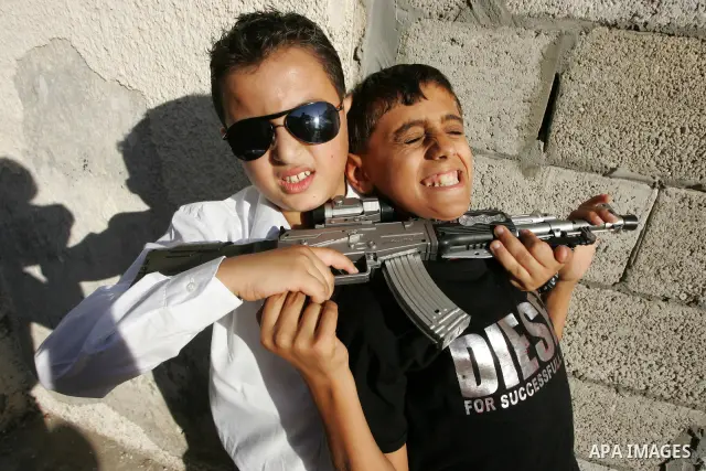 Palestinian boys play with toy guns on the third day of the Eid al-Fitr holiday in Rafah Refugee Camp in the southern Gaza Strip on 01 September 2011. Eid marks the end of the holy month of Ramadan. Photo by Abed Rahim K...