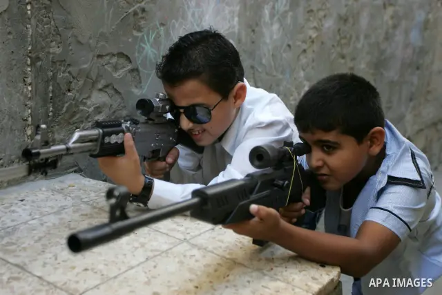 Palestinian boys play with toy guns on the third day of the Eid al-Fitr holiday in Rafah Refugee Camp in the southern Gaza Strip on 01 September 2011. Eid marks the end of the holy month of Ramadan. Photo by Abed Rahim K...
