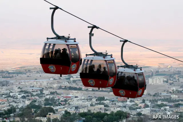 Tourists tour the historic sites of Jericho in cable cars during celebrations on the third day of the Eid al-Fitr holiday, which marks the end of the holy fasting month of Ramadan in the West Bank city of Jericho on Sept...
