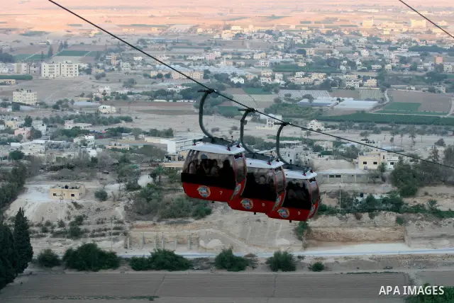 Tourists tour the historic sites of Jericho in cable cars during celebrations on the third day of the Eid al-Fitr holiday, which marks the end of the holy fasting month of Ramadan in the West Bank city of Jericho on Sept...