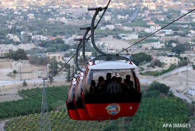 Tourists tour the historic sites of Jericho in cable cars during celebrations on the third day of the Eid al-Fitr holiday, which marks the end of the holy fasting month of Ramadan in the West Bank city of Jericho on Sept...