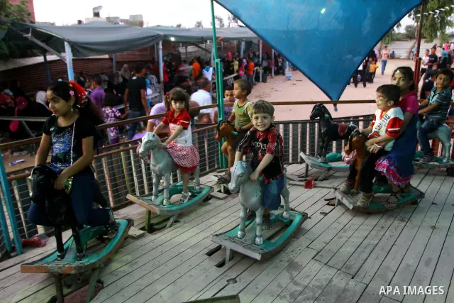 Palestinian children enjoy a ride at an amusement park on the third day of the Eid al-Fitr holiday, which marks the end of the holy fasting month of Ramadan in Gaza city on Sept. 1,2011. Photo by Ashraf Amra