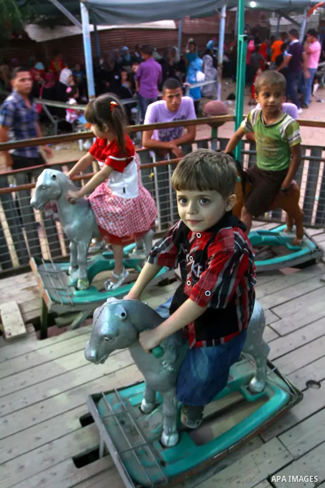 Palestinian children enjoy a ride at an amusement park on the third day of the Eid al-Fitr holiday, which marks the end of the holy fasting month of Ramadan in Gaza city on Sept. 1,2011. Photo by Ashraf Amra