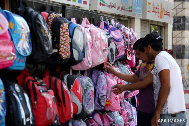 Palestinians walk past school bags as vendors display them in the preparation of new school year in a market in the West Bank city of Nablus on Sept. 03, 2011. The Palestinian students in the West Bank and Gaza Strip wil...