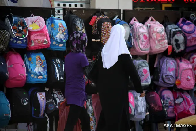 Palestinians walk past school bags as vendors display them in the preparation of new school year in a market in the West Bank city of Nablus on Sept. 03, 2011. The Palestinian students in the West Bank and Gaza Strip wil...