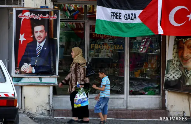 Palestinians walk past a poster of the Turkish Prime Minister Recep Tayyip Erdogan, the Arabic written on the poster "Palestine people love you", in Gaza city on Sep 3,2011. Turkey said Friday it was expelling the Israel...