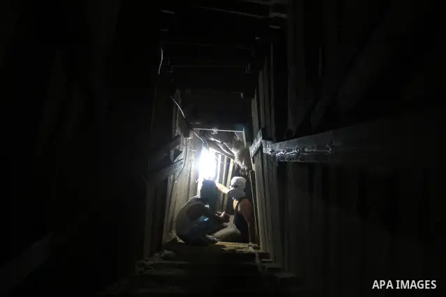 Palestinian tunnel digger, wearing a mask to conceal his identity, removes sand in a bucket from a tunnel underground in Rafah, in the southern Gaza Strip, on the border with Egypt on Sep. 4, 2011. Egyptian military Corp...