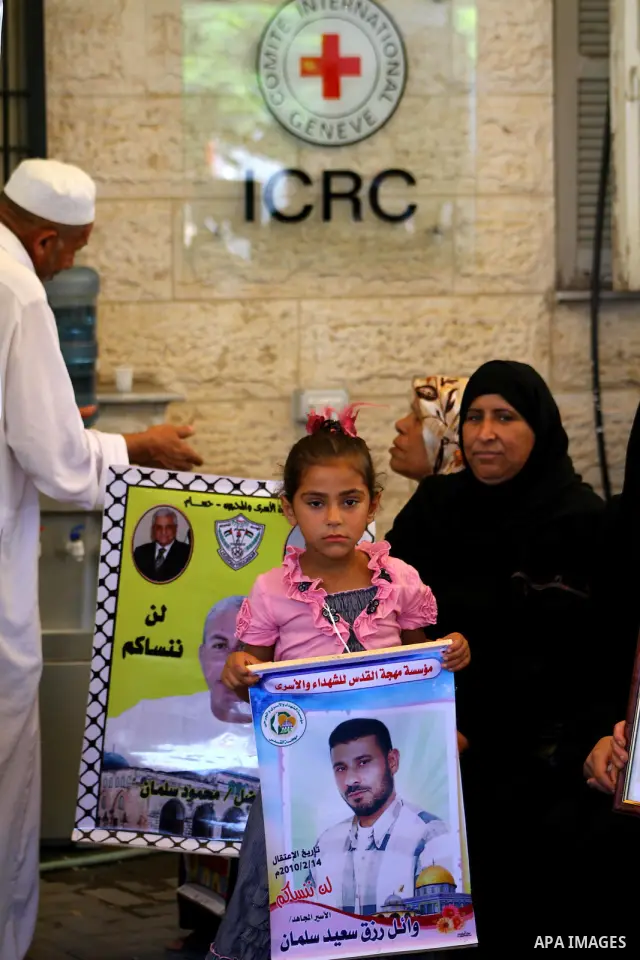 Palestinians hold pictures of their prisoned relatives in Israeli jails as they gather in a weekly activity calling for their liberty at the Red Cross headquarters in Gaza City onSep. 5, 2011. About 7000 prisoners are in...