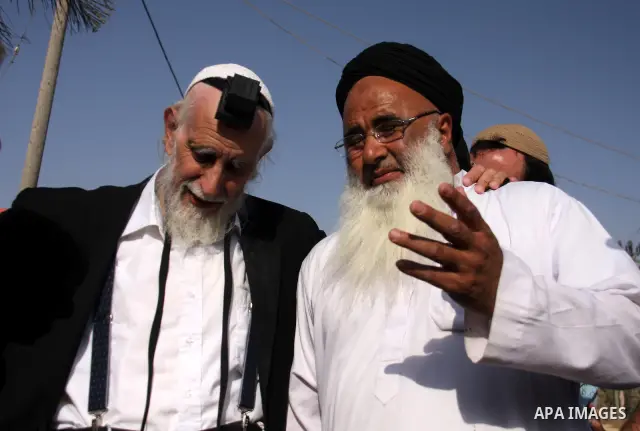 Jewish rabbi Menachem Froman leads a reconciliation visit of Jewish settlers to the West Bank village of Qusra, a day after the local mosque was vandalized, Tuesday, Sept. 6, 2011. The mosque was torched Monday after Isr...