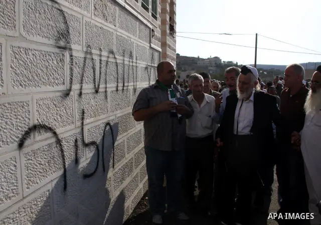 Jewish rabbi Menachem Froman leads a reconciliation visit of Jewish settlers to the West Bank village of Qusra, a day after the local mosque was vandalized, Tuesday, Sept. 6, 2011. The mosque was torched Monday after Isr...