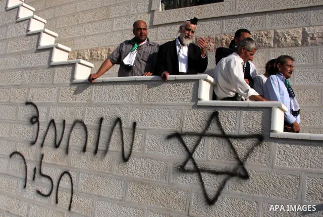 Jewish rabbi Menachem Froman leads a reconciliation visit of Jewish settlers to the West Bank village of Qusra, a day after the local mosque was vandalized, Tuesday, Sept. 6, 2011. The mosque was torched Monday after Isr...
