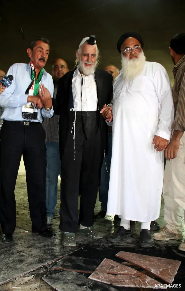Jewish rabbi Menachem Froman leads a reconciliation visit of Jewish settlers to the West Bank village of Qusra, a day after the local mosque was vandalized, Tuesday, Sept. 6, 2011. The mosque was torched Monday after Isr...