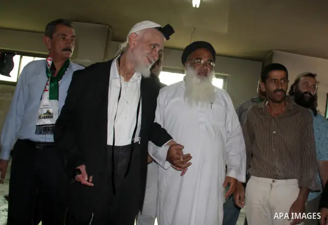 Jewish rabbi Menachem Froman leads a reconciliation visit of Jewish settlers to the West Bank village of Qusra, a day after the local mosque was vandalized, Tuesday, Sept. 6, 2011. The mosque was torched Monday after Isr...