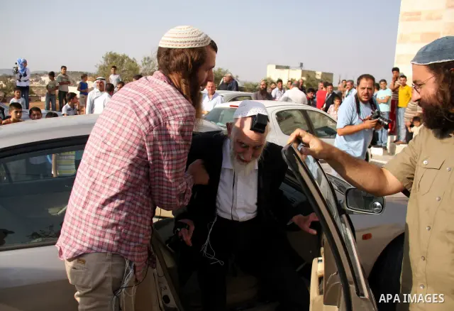 Jewish rabbi Menachem Froman leads a reconciliation visit of Jewish settlers to the West Bank village of Qusra, a day after the local mosque was vandalized, Tuesday, Sept. 6, 2011. The mosque was torched Monday after Isr...