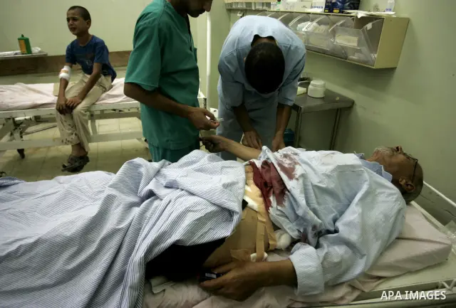 A wounded Palestinian father and his son receive medical care on September 6, 2011 at a hospital in Khan Yunis, following an Israeli air strike east of the central Gaza Strip city in which a Palestinian militant was kill...