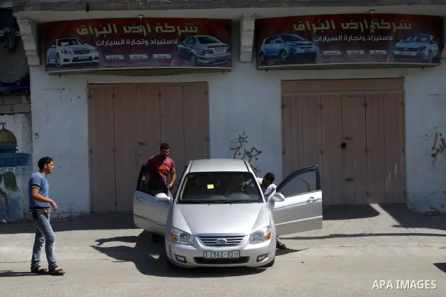 Palestinians watch cars, at a showroom in Gaza City on Sep. 7, 2011. while Israel stop to enter cars into Gaza Strip again after it allowed to enter them as a part of a new strategy to increase Gaza blockade. Photo by Ma...