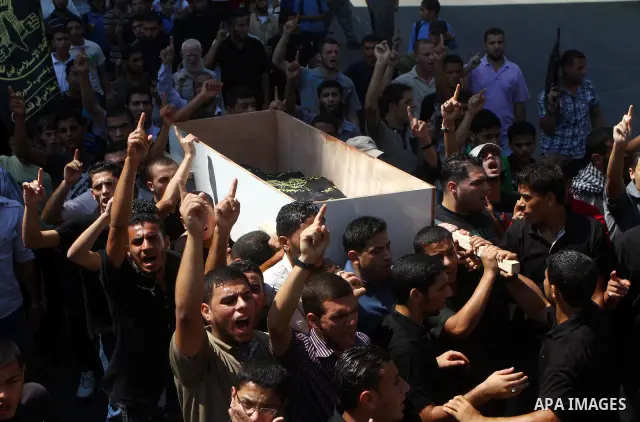 Palestinian mourners carry the body of Remah al-Hasani, a member of its military wing, the Al-Quds Brigades, during his funeral in Gaza city on Sep. 8, 2011. He was killed as he was driving in the central Deir al-Balah d...