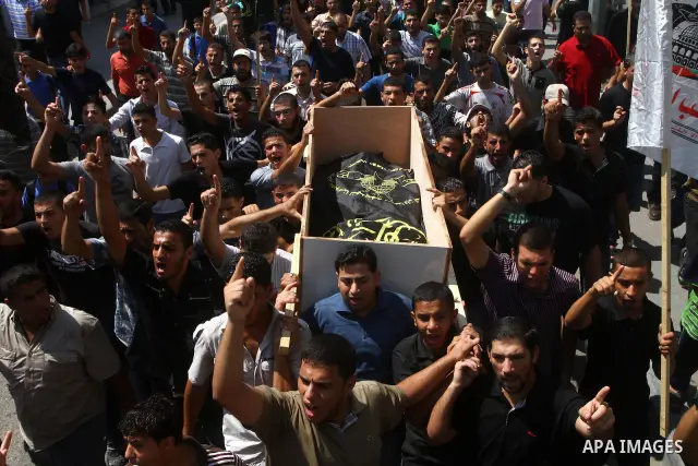 Palestinian mourners carry the body of Remah al-Hasani, a member of its military wing, the Al-Quds Brigades, during his funeral in Gaza city on Sep. 8, 2011. He was killed as he was driving in the central Deir al-Balah d...