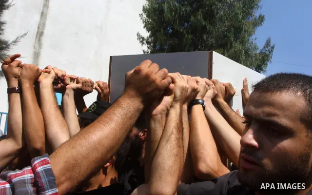 Palestinian mourners carry the body of Remah al-Hasani, a member of its military wing, the Al-Quds Brigades, during his funeral in Gaza city on Sep. 8, 2011. He was killed as he was driving in the central Deir al-Balah d...
