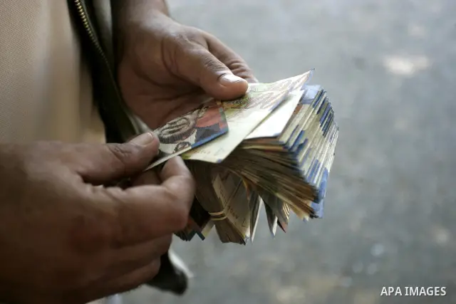 A Palestinian man exchanges currency, in the in city of Rafah the southern Gaza Strip, the U.S. dollar and shekel in black markets in the Gaza Strip on Sep. 8, 2011. Significant increase to the U.S. dollar $1000 against...
