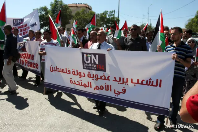 Palestinians hold banners and flags as they march during the launch of a campaign supporting a bid for Palestinian statehood recognition at the U.N, in the West Bank city of Ramallah on Sep. 8, 2011. A member of the camp...