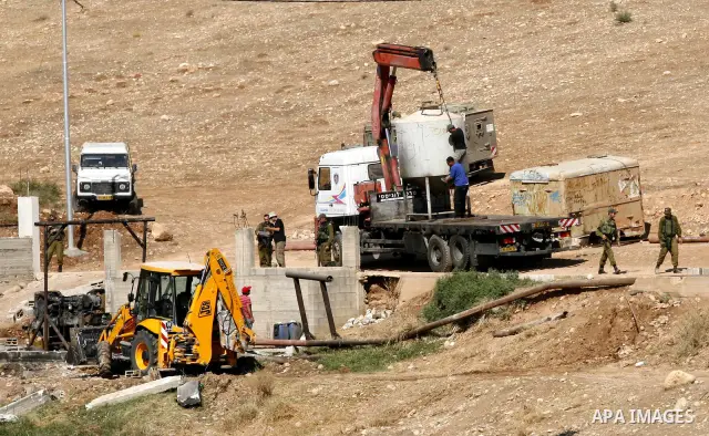 Israeli soldiers surround a bulldozer as it destroys a Palestinian water well in the northern West Bank village of Al-Nassariya, Thursday, Sept. 8, 2011. The Israeli civil administration told Palestinian residents in the...
