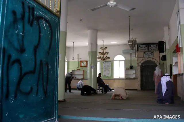 Palestinians attend praying at a mosque whose door was vandalized with the Hebrew words "PR (Price Tag) Migron" in the northern West Bank village of Yatma, Thursday, Sept. 8, 2011. Israeli West Bank settlers, meanwhile,...
