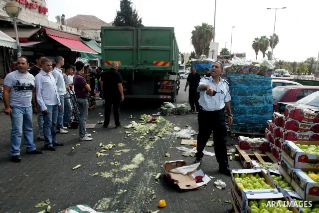 Israeli policemen and municipality employees confiscate the Palestinian sellers' vegetables and fruit in Jerusalem's old city on Sep. 9,2011. Photo by Mahfouz Abu Turk