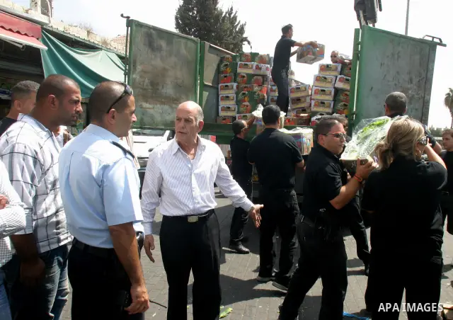 Israeli policemen and municipality employees confiscate the Palestinian sellers' vegetables and fruit in Jerusalem's old city on Sep. 9,2011. Photo by Mahfouz Abu Turk