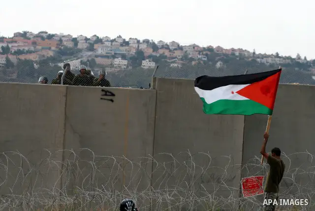 A Palestinian man waves a flag during a demonstration in the West Bank town of Bilin, near Ramallah, Friday, Sept. 9, 2011. The Palestinians have launched a campaign to rally support for U.N. recognition as an independen...