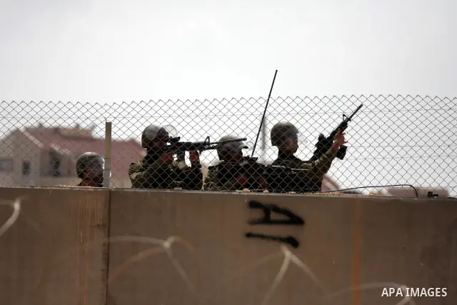 Israeli soldiers stand behind the separation wall between Israel and Palestine during a demonstration in the West Bank town of Bilin, near Ramallah, Friday, Sept. 9, 2011. The Palestinians have launched a campaign to ral...