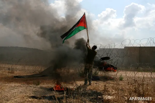 A Palestinian man waves a flag during a demonstration in the West Bank town of Bilin, near Ramallah, Friday, Sept. 9, 2011. The Palestinians have launched a campaign to rally support for U.N. recognition as an independen...