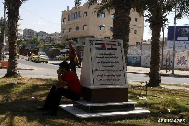 A Palestinian man sits on the memorial site in memory of the Egyptian policemen who were killed by the Israeli army in Gaza city on Sep.10, 2011. While the Egyptians held a series of protests in front of the Israeli emba...