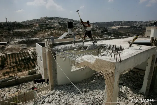 Palestinian Jerusalem resident Adnan Taha destroys his own home with a fellow Palestinian in Arab east Jerusalem on September 11, 2011, in implementation of an Israeli court order which ruled that the house was built wit...