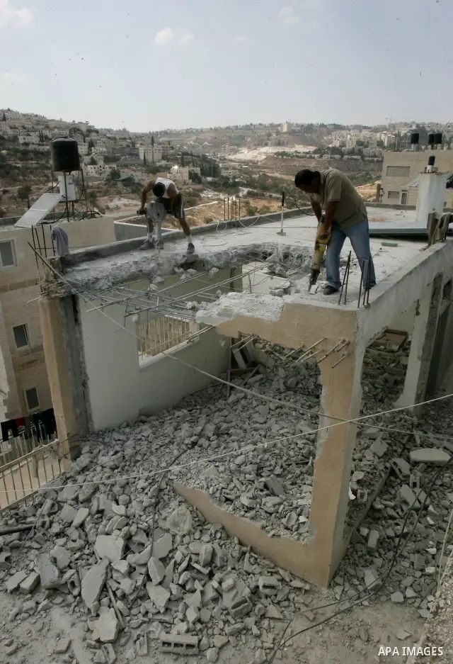 Palestinian Jerusalem resident Adnan Taha destroys his own home with a fellow Palestinian in Arab east Jerusalem on September 11, 2011, in implementation of an Israeli court order which ruled that the house was built wit...