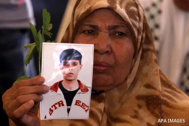 A Palestinian woman holds picture of her prisoned relative in Israeli jails as they gather in a weekly activity calling for their liberty at the Red Cross headquarters in Gaza City on Sep. 12, 2011. About 7000 prisoners...