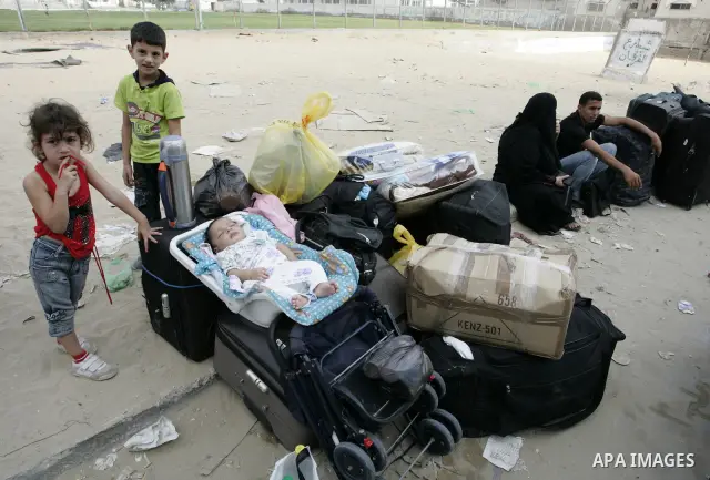 Palestinians sit near their luggage as they wait to cross into Egypt through the Rafah border crossing in the southern Gaza Strip on Sep 12, 2011. Photo by Abed Rahim Khatib
