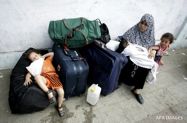 Palestinians sit near their luggage as they wait to cross into Egypt through the Rafah border crossing in the southern Gaza Strip on Sep 12, 2011. Photo by Abed Rahim Khatib