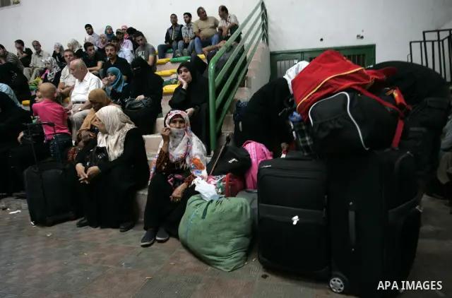 Palestinians sit near their luggage as they wait to cross into Egypt through the Rafah border crossing in the southern Gaza Strip on Sep 12, 2011. Photo by Abed Rahim Khatib