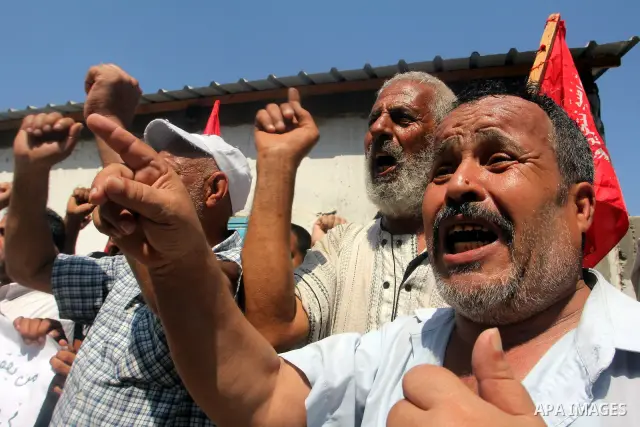 Palestinians shout slogans during a rally supporting a bid for Palestinian statehood recognition at the U.N., at a United Nations Relief and Works Agency (UNRWA) food distribution center in Rafah in the southern Gaza Str...