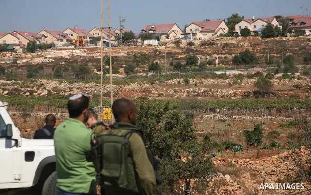Israeli soldiers inspect the area after a Palestinian vineyard was damaged by suspected Jewish settlers from the nearby settlement Karmi Tasour in the West Bank village of Beit Omar, near Hebron on 12 September 2011. Med...