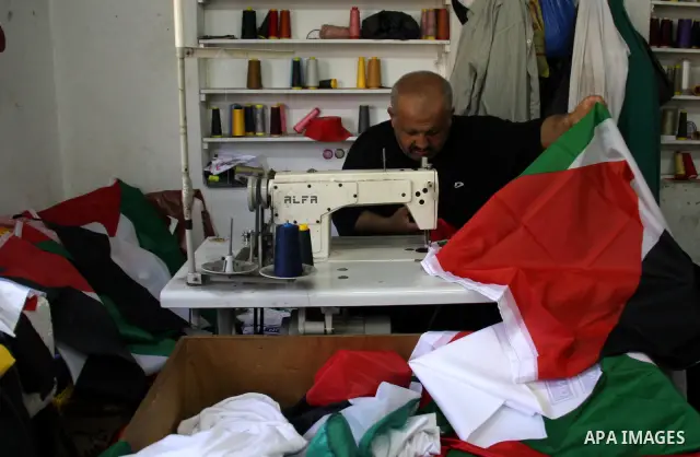 A Palestinian tailor sews national flags to be used in the national campaign to promote the Palestinian bid to obtain statehood recognition at the United Nations, at a factory in the West Bank city of Nablus on Sep. 13,...