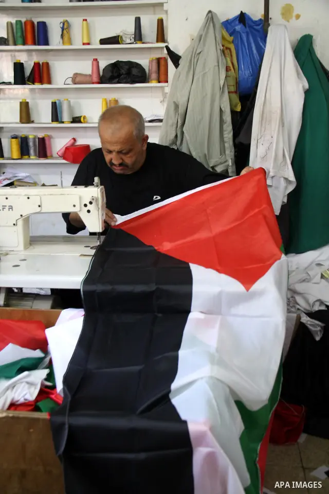 A Palestinian tailor sews national flags to be used in the national campaign to promote the Palestinian bid to obtain statehood recognition at the United Nations, at a factory in the West Bank city of Nablus on Sep. 13,...